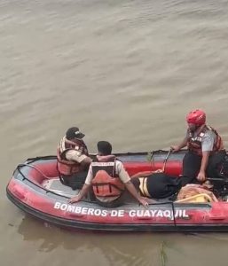 Rescatistas del Cuerpo de Bomberos de Guayaquil retiran Del Río Guayas el cadáver de una mujer.
